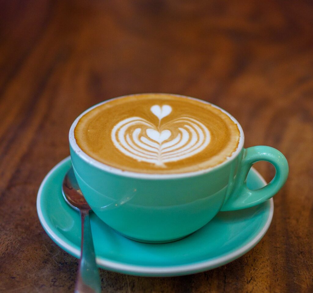 coffee in a green, round, wide-mouth cup like a French bowl and a green saucer