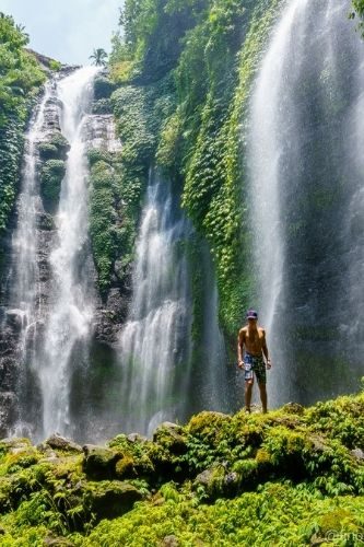 shirtless man in front of Fiji waterfalls Bali, Indonesia