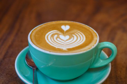 coffee in a green, round, wide-mouth cup like a French bowl and a green saucer